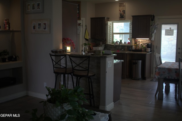 3136 Red Crk, El Paso, TX 79938 - kitchen with a breakfast bar, a peninsula, light wood-type flooring, backsplash, and a sink