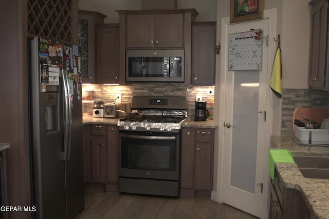 3136 Red Crk, El Paso, TX 79938 - kitchen with stainless steel appliances, backsplash, light stone countertops, and a sink