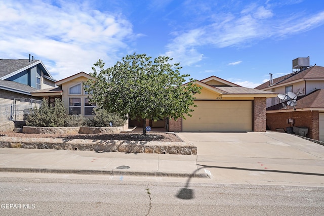 4513 Gen Maloney Cir, El Paso, TX 79924 - obstructed view of property with an attached garage, concrete driveway, and brick siding