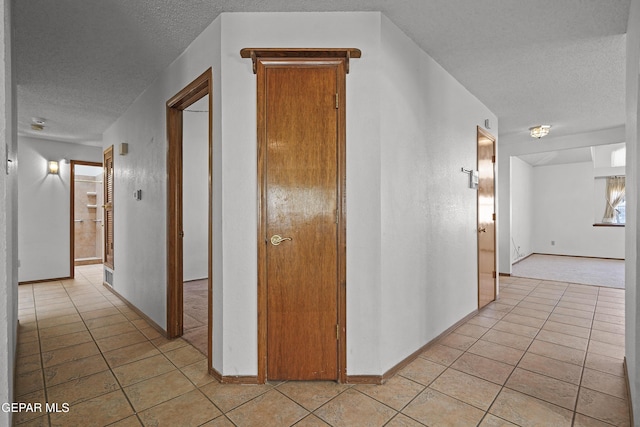 4513 Gen Maloney Cir, El Paso, TX 79924 - hall featuring a textured ceiling, light tile patterned flooring, and baseboards