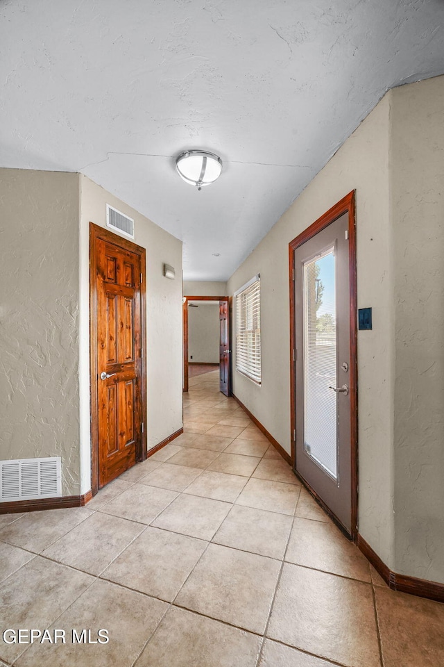 5300 Crawford Rd, Santa Teresa, NM 88008 - hallway with a textured wall, light tile patterned floors, and baseboards
