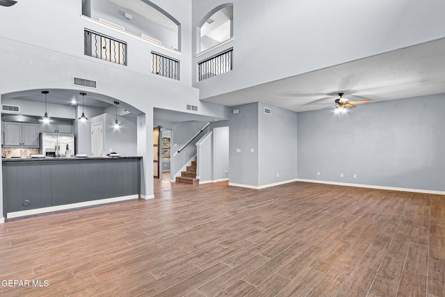 14045 Tower Point Way, El Paso, TX 79938 - unfurnished living room with a ceiling fan, light wood finished floors, baseboards, and stairs