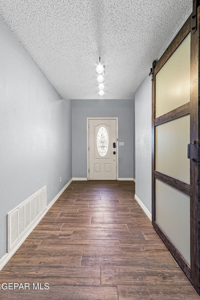 14045 Tower Point Way, El Paso, TX 79938 - foyer featuring a barn door, wood finished floors, a textured ceiling, and baseboards