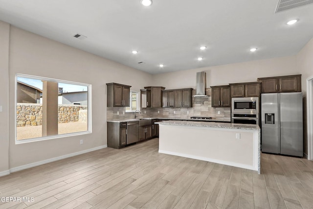 3952 Aspiration St, El Paso, TX 79938 - kitchen with stainless steel appliances, wall chimney exhaust hood, dark brown cabinetry, light wood-type flooring, and recessed lighting