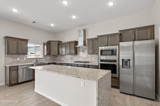 3952 Aspiration St, El Paso, TX 79938 - kitchen featuring stainless steel appliances, wall chimney exhaust hood, a sink, dark brown cabinets, and a center island