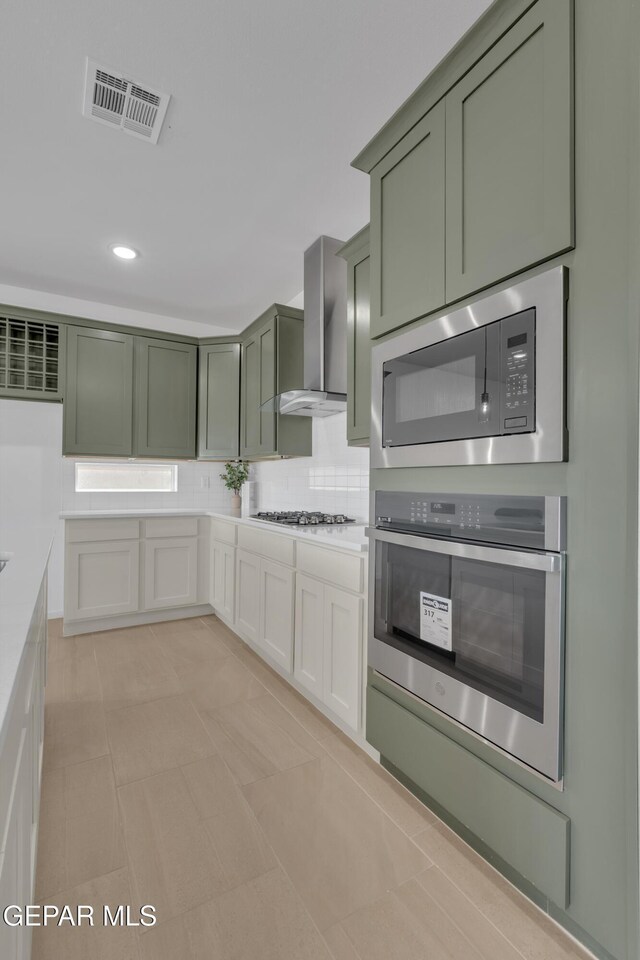 13873 Madero Ave, Horizon City, TX 79928 - kitchen with green cabinets, stainless steel appliances, wall chimney range hood, light countertops, and recessed lighting