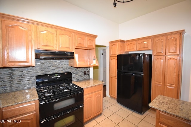 3608 Douglas Ave, El Paso, TX 79903 - kitchen featuring black appliances, under cabinet range hood, light tile patterned flooring, and tasteful backsplash