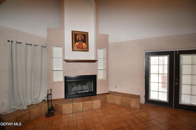 3608 Douglas Ave, El Paso, TX 79903 - unfurnished living room featuring tile patterned floors, a fireplace, french doors, and a high ceiling