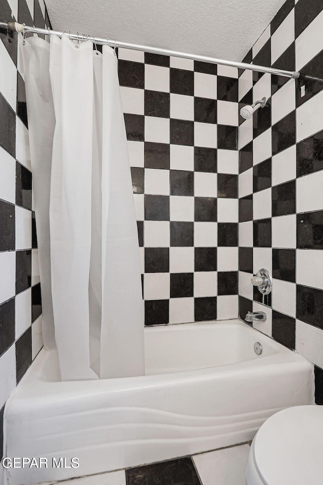 816 Ellis St, El Paso, TX 79903 - bathroom with shower / tub combo, a textured ceiling, and toilet