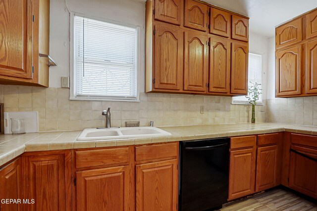 816 Ellis St, El Paso, TX 79903 - kitchen featuring dishwasher, a sink, brown cabinetry, and backsplash