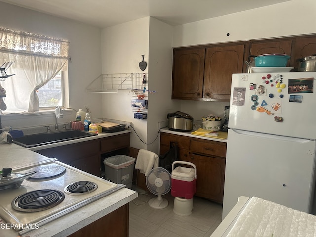10477 Mackinaw St, El Paso, TX 79924 - kitchen featuring freestanding refrigerator, light countertops, a sink, and range