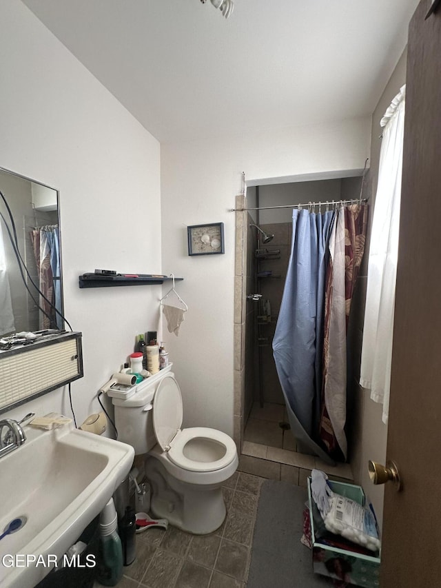 10477 Mackinaw St, El Paso, TX 79924 - bathroom featuring toilet, a stall shower, a sink, and tile patterned floors