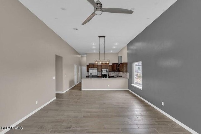 3928 Aspiration, El Paso, TX 79934 - unfurnished living room featuring ceiling fan, wood finished floors, baseboards, and recessed lighting