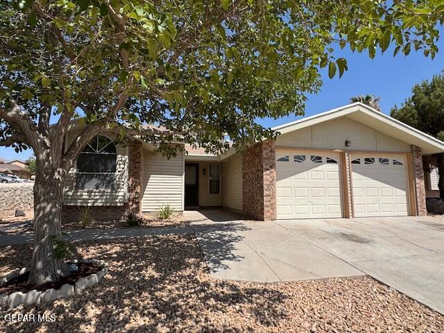 684 Abington Dr, El Paso, TX 79912 - view of front facade featuring brick siding, a garage, and concrete driveway