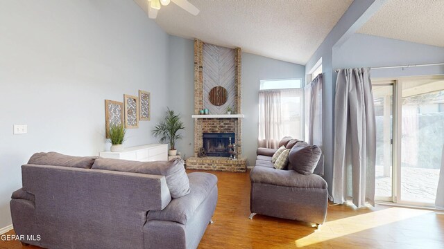 684 Abington Dr, El Paso, TX 79912 - living area with vaulted ceiling, wood finished floors, a fireplace, a ceiling fan, and a textured ceiling
