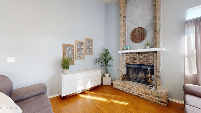 684 Abington Dr, El Paso, TX 79912 - living room featuring a fireplace, a high ceiling, wood finished floors, and baseboards