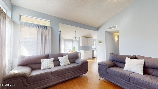 684 Abington Dr, El Paso, TX 79912 - living area featuring light wood finished floors, a textured ceiling, and lofted ceiling