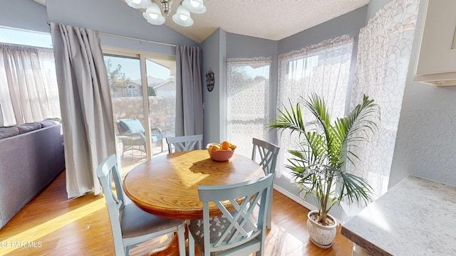 684 Abington Dr, El Paso, TX 79912 - dining room with a chandelier, light wood finished floors, lofted ceiling, a textured ceiling, and a textured wall