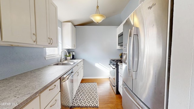 684 Abington Dr, El Paso, TX 79912 - kitchen featuring stainless steel appliances, a sink, light wood-style floors, baseboards, and light countertops