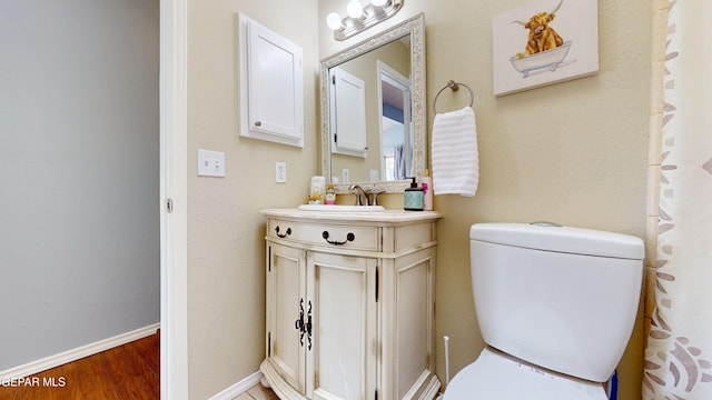 684 Abington Dr, El Paso, TX 79912 - bathroom with toilet, vanity, wood finished floors, and baseboards