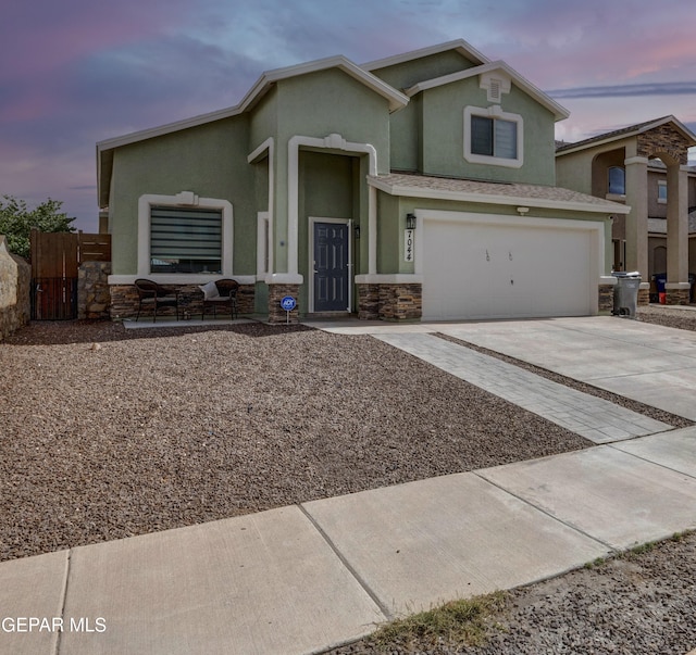 7044 Eagle Nest Ct, El Paso, TX 79934 - view of front of house with stone siding, concrete driveway, a garage, and stucco siding