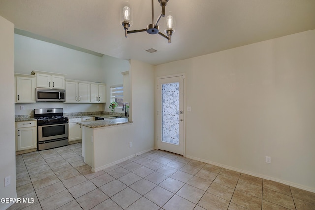7044 Eagle Nest Ct, El Paso, TX 79934 - kitchen with appliances with stainless steel finishes, white cabinets, light tile patterned floors, baseboards, and a peninsula