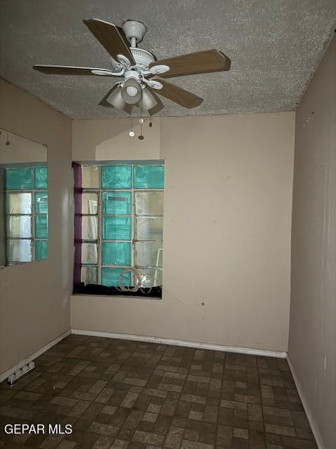 7901 Lirio Rd, El Paso, TX 79915 - spare room featuring a textured ceiling, a ceiling fan, baseboards, and brick patterned flooring