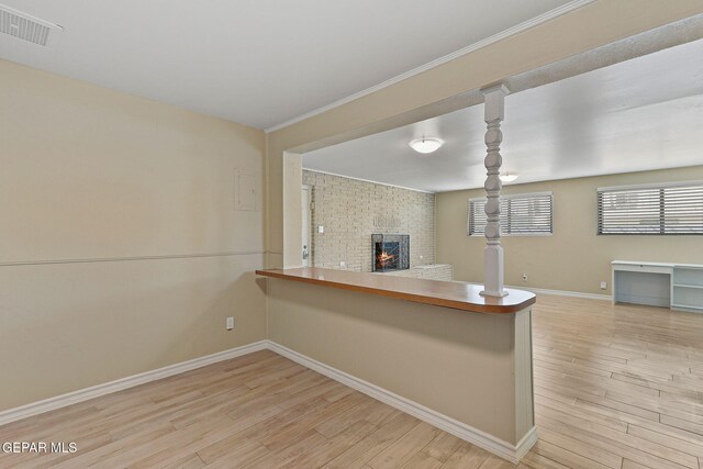 310 Kelvin Ave, El Paso, TX 79915 - kitchen with light wood-style flooring, baseboards, open floor plan, a fireplace, and a peninsula