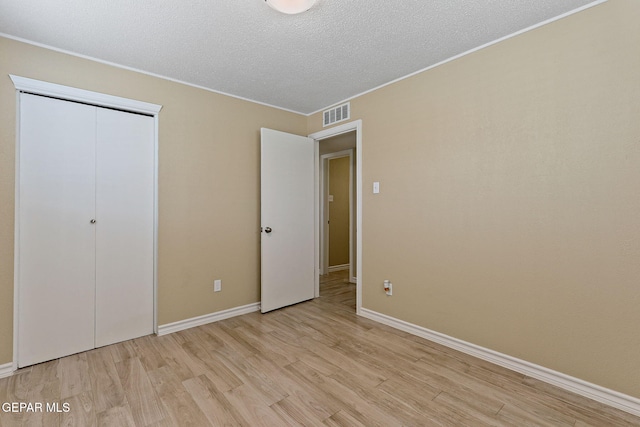 310 Kelvin Ave, El Paso, TX 79915 - unfurnished bedroom featuring light wood-style floors, a textured ceiling, baseboards, a closet, and ornamental molding