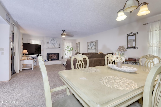 11625 Soberana Ln Unit A & B, El Paso, TX 79936 - dining area with ceiling fan, carpet flooring, a brick fireplace, and a textured ceiling