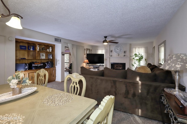 11625 Soberana Ln Unit A & B, El Paso, TX 79936 - carpeted dining space featuring ceiling fan, a textured ceiling, and a brick fireplace