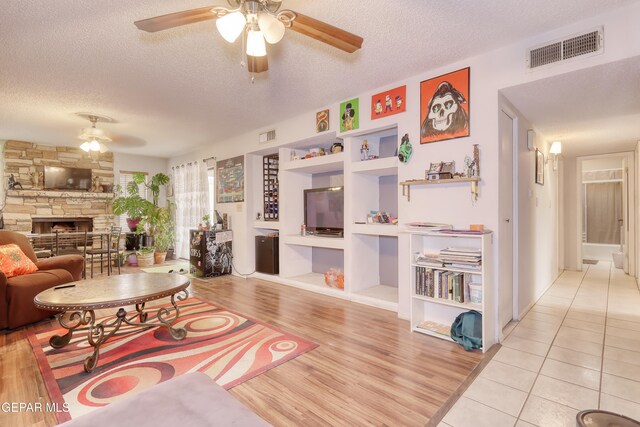 11625 Soberana Ln Unit A & B, El Paso, TX 79936 - living area with ceiling fan, a textured ceiling, wood finished floors, a fireplace, and built in features