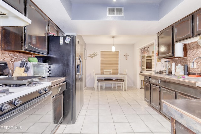 11625 Soberana Ln Unit A & B, El Paso, TX 79936 - kitchen featuring a sink, white range with gas stovetop, tasteful backsplash, light tile patterned floors, and under cabinet range hood