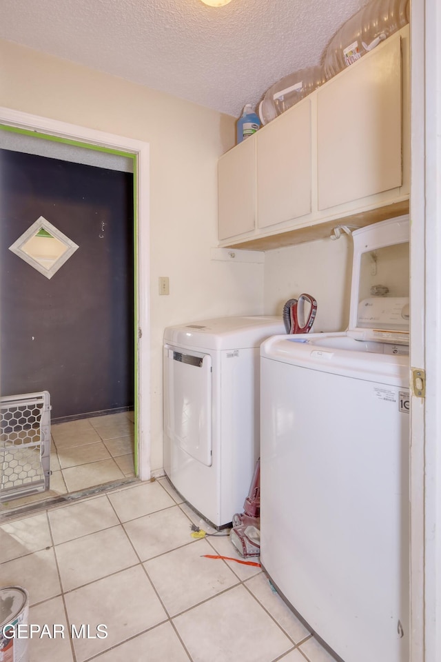 11625 Soberana Ln Unit A & B, El Paso, TX 79936 - washroom featuring cabinet space, washer and clothes dryer, light tile patterned floors, and a textured ceiling