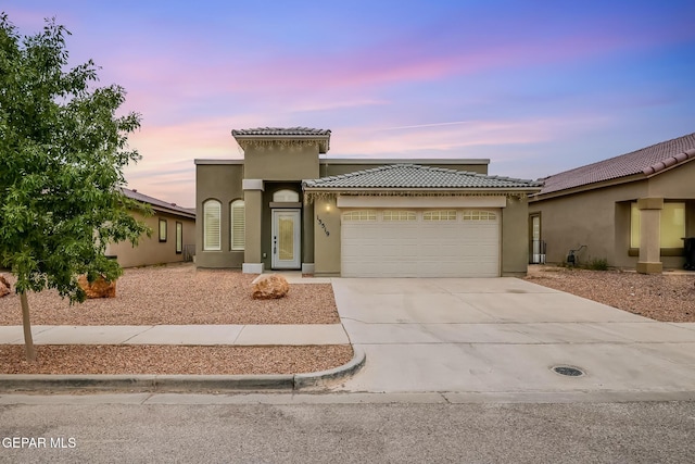 13519 Hazlewood St, El Paso, TX 79928 - mediterranean / spanish-style house featuring an attached garage, concrete driveway, a tile roof, and stucco siding