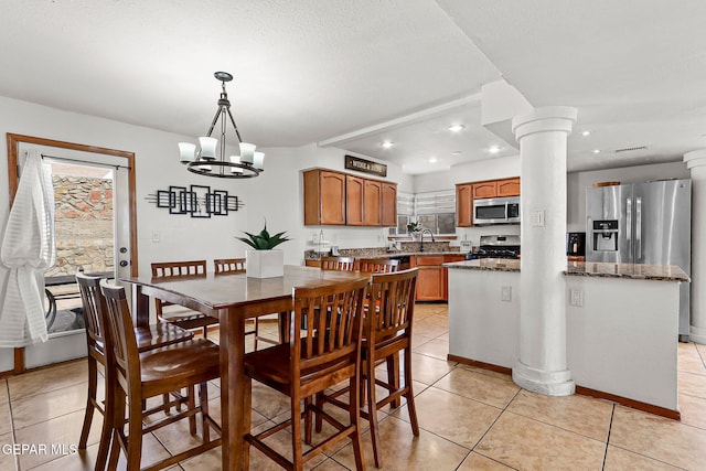1328 Morgan Marie St, El Paso, TX 79936 - dining room with healthy amount of natural light, light tile patterned floors, a chandelier, recessed lighting, and decorative columns