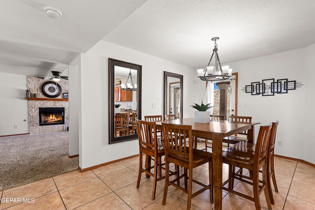 1328 Morgan Marie St, El Paso, TX 79936 - dining room with a chandelier, light tile patterned flooring, a tile fireplace, baseboards, and a ceiling fan