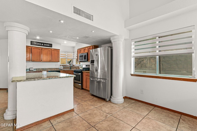 1328 Morgan Marie St, El Paso, TX 79936 - kitchen with appliances with stainless steel finishes, decorative columns, brown cabinets, dark stone countertops, and recessed lighting