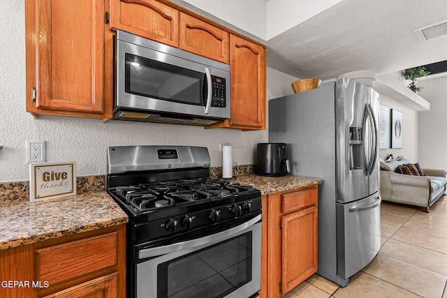 1328 Morgan Marie St, El Paso, TX 79936 - kitchen featuring stainless steel appliances, brown cabinets, and light tile patterned flooring
