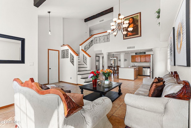 1328 Morgan Marie St, El Paso, TX 79936 - living area featuring high vaulted ceiling, a chandelier, light tile patterned floors, stairway, and ornate columns