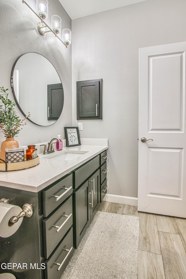 12826 Osmotherly Ave, El Paso, TX 79928 - bathroom featuring wood finished floors, vanity, and baseboards