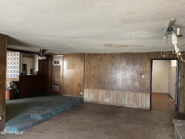5608 Paraguay Ct, El Paso, TX 79903 - empty room with wood walls, a textured ceiling, and ceiling fan
