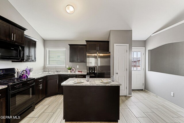 401 Gran Villa Pl, Socorro, TX 79927 - kitchen with black appliances, a center island, vaulted ceiling, a sink, and dark brown cabinets
