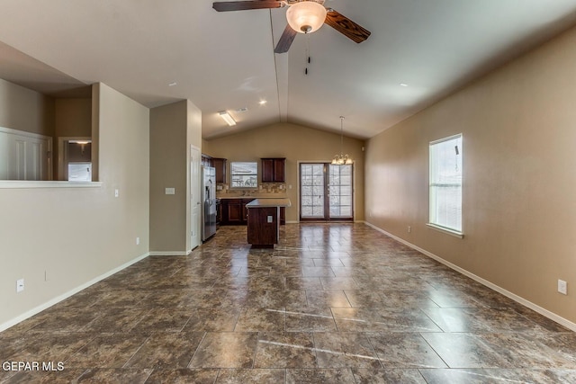 2412 Escape Point St, El Paso, TX 79938 - unfurnished living room featuring a chandelier, vaulted ceiling, baseboards, ceiling fan, and dark stone finish floors
