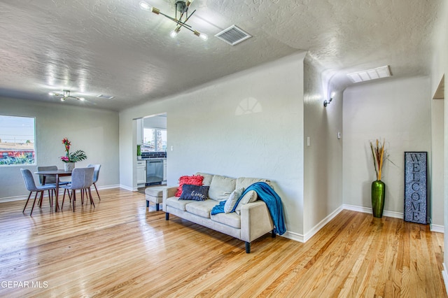 1401 N Boone St, El Paso, TX 79903 - living area featuring a textured ceiling, light wood finished floors, and baseboards