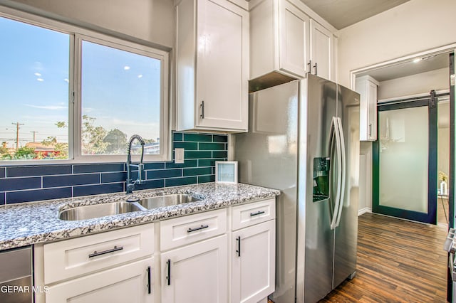 1401 N Boone St, El Paso, TX 79903 - kitchen with a sink, stainless steel fridge, tasteful backsplash, a barn door, and white cabinetry