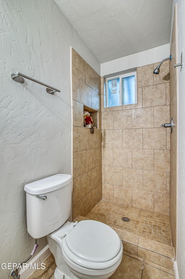 1401 N Boone St, El Paso, TX 79903 - bathroom featuring a tile shower, toilet, and baseboards