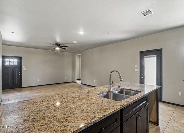 14425 Donny Murray Ln, Horizon City, TX 79928 - kitchen featuring a sink, a ceiling fan, light tile patterned floors, light stone counters, and baseboards