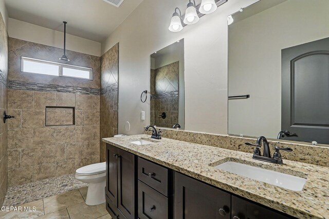 14425 Donny Murray Ln, Horizon City, TX 79928 - full bath featuring double vanity, toilet, a tile shower, and tile patterned flooring