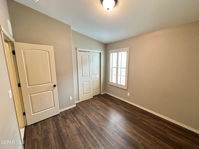 7217 Long Meadow Dr, El Paso, TX 79934 - unfurnished bedroom featuring lofted ceiling, dark wood-style flooring, a closet, and baseboards